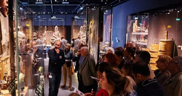 Photographie d'une visite guidée dans la section Europe de l'exposition permanente du MEG.