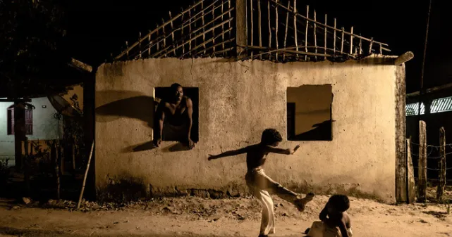 Enfants dansants la capoeira devant une maison