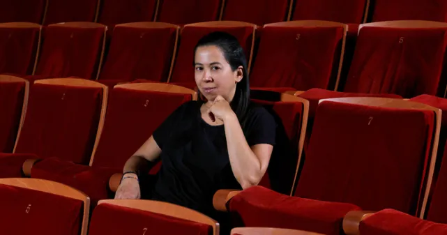 Anne NGuyen assise dans un Auditorium